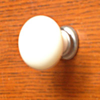 ART55430 Ceramic Knob in Antique Cream finish with a Burnished Iron mount.